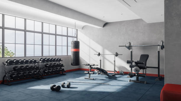 Interior of an empty modern gym fitness room with large windows.